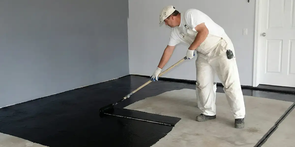 basement waterproofing professional applying waterproof coating to protect a basement floor in Chandler, AZ